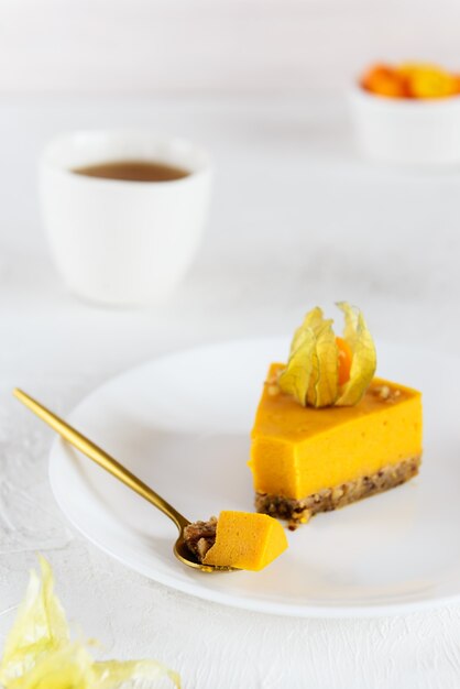 Una rebanada de pastel de calabaza decorada con physalis