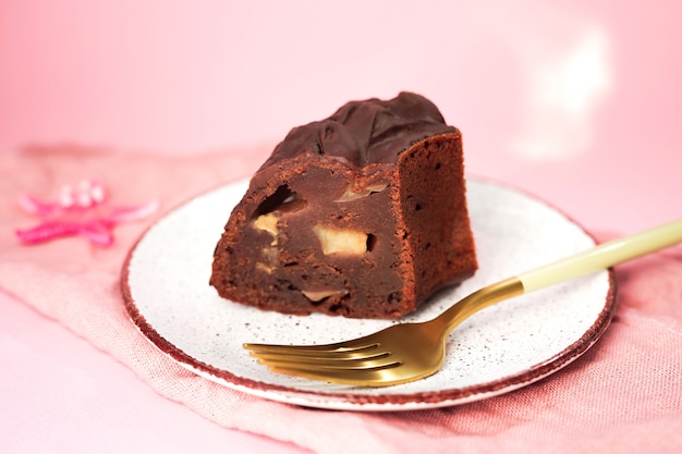 Una rebanada de pastel de chocolate con manzanas en un plato blanco