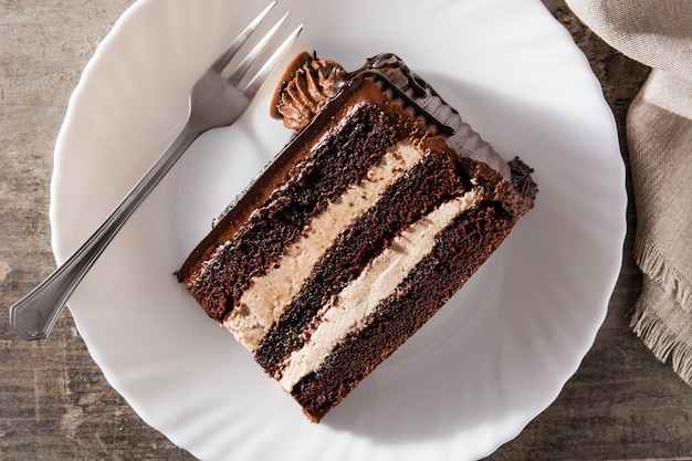 Rebanada de pastel de chocolate en mesa de madera