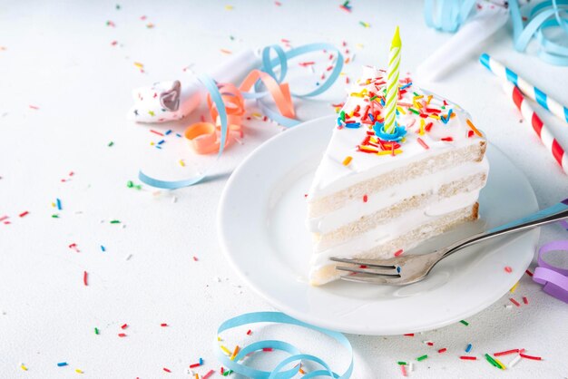 Una rebanada de pastel de cumpleaños en la mesa decorada de la fiesta de cumpleañas