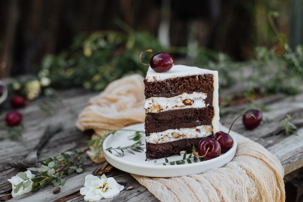 Rebanada de pastel decorado con cereza en una mesa de madera