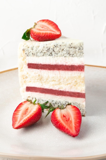 Una rebanada de pastel de fresa en un plato gris decorado con fresas Primer plano sobre un fondo blanco