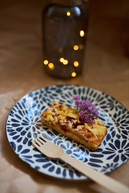 Una rebanada de pastel de masa quebrada casero relleno con manzanas y ciruelas Pie sobre un fondo bokeh