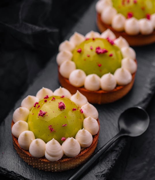 Una rebanada de pastel de matcha con vainilla y frambuesas