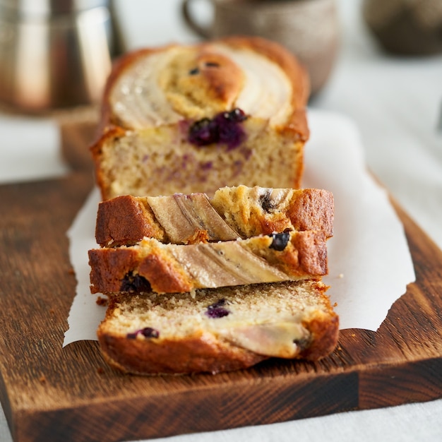 Rebanada de pastel de pan de plátano con plátano y arándanos desayuno matutino con café