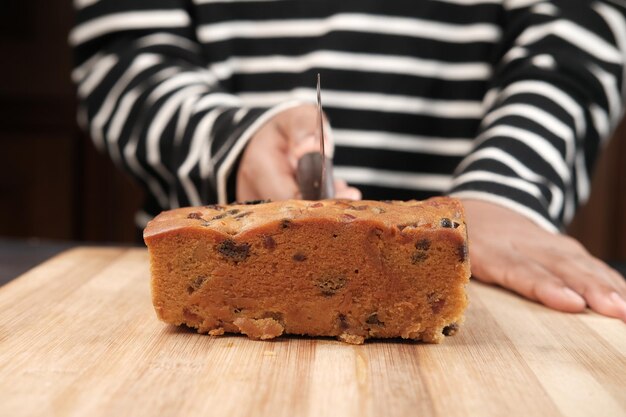 Rebanada de pastel de panadería sobre una tabla de cortar en blanco