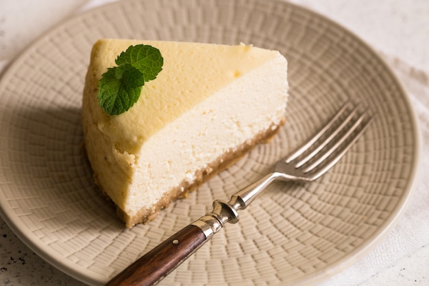 Rebanada De Pastel De Queso Clásico De Nueva York En Un Plato Blanco. Vista de cerca Panadería casera