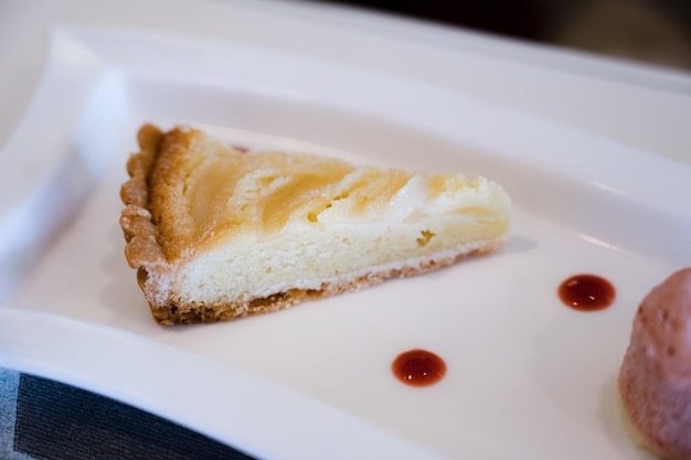 Una rebanada de pastel de queso con crema blanca encima