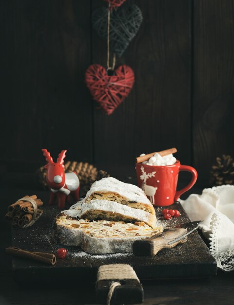 Rebanada de pastel tradicional europeo Stollen con nueces y frutas confitadas espolvoreadas con azúcar glas, cerrar