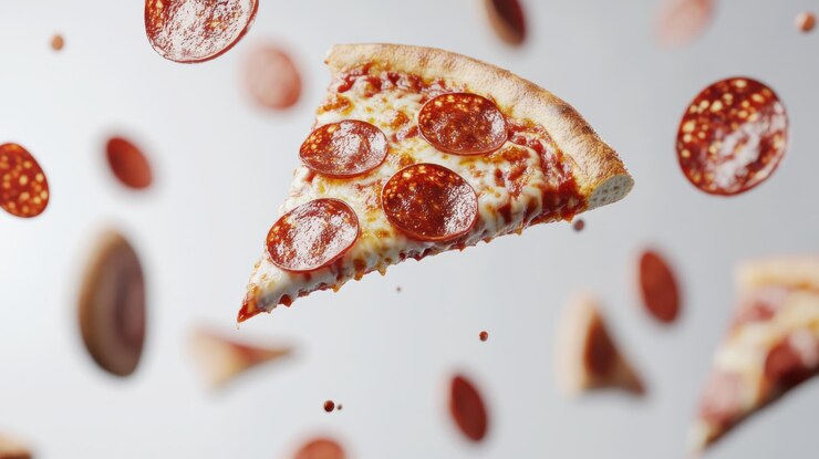 Una rebanada de pizza de pepperoni con ingredientes voladores en un fondo blanco