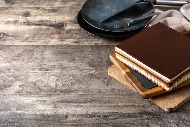 Rebanada de postre de pastel de ópera en mesa de madera