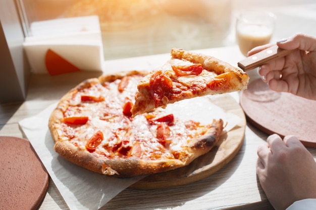 Rebanada de primer plano de pizza. Pizza se encuentra en una mesa en un café