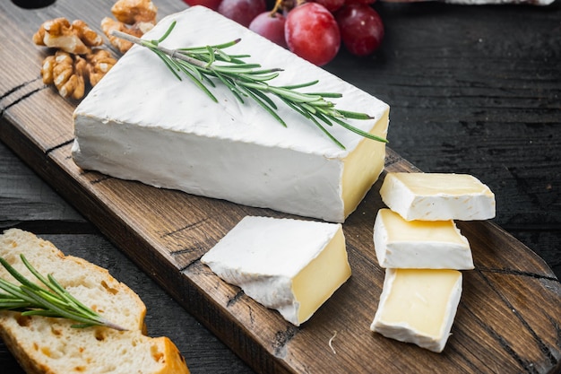 Rebanada de queso brie cremoso de granja sobre una mesa de madera negra