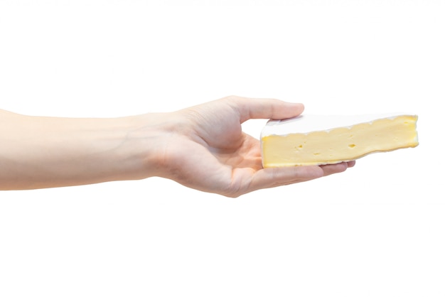 Una rebanada de queso fresco del brie en la mano de los hombres aislada en blanco