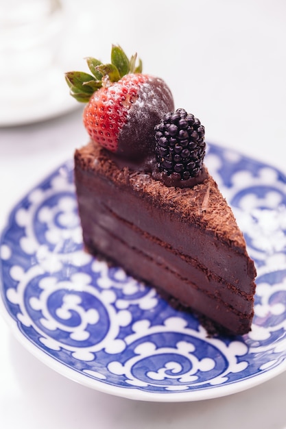 Rebanada de relleno de tarta de chocolate con fresas frescas y moras.