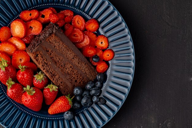 Rebanada de sabroso pastel de chocolate con fresas cortadas