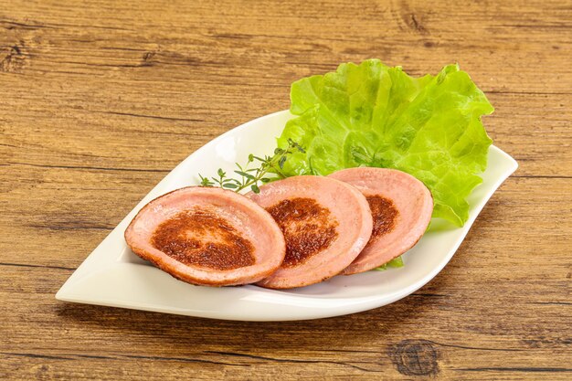 Rebanada de salchicha asada en el plato