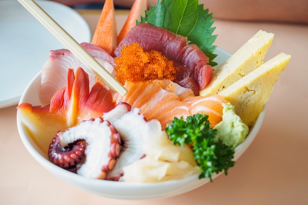 Rebanada de salmón en palillos, comiendo plato de arroz sashimi Chirashi Don comida japonesa