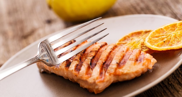 Foto rebanada de salmón a la parrilla cortada con un tenedor