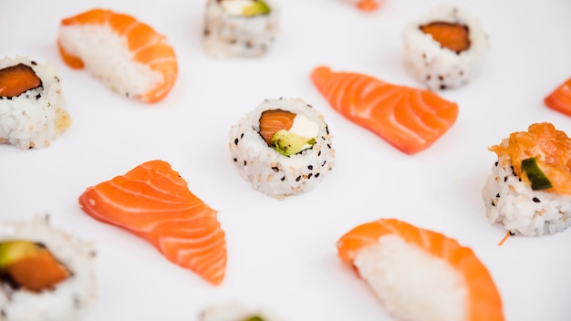 Rebanada de salmón y sushi aislado sobre fondo blanco