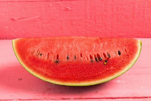 Rebanada de sandía madura en madera rosa