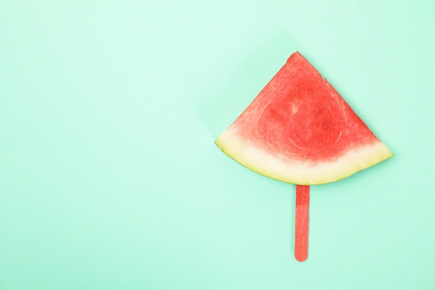 Rebanada de sandía en palito de helado en menta. Fruta de verano