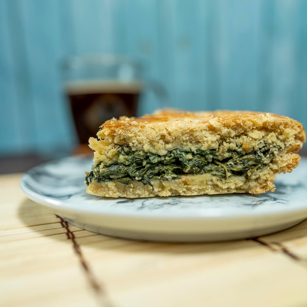 rebanada de tarta de acelgas servida con café