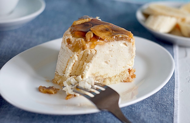 Foto una rebanada de tarta de queso con plátano fresco en un plato con bana