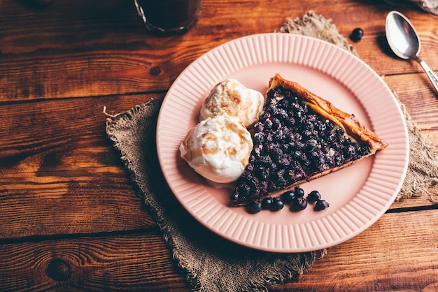 Rebanada de tarta Serviceberry y dos bolas de helado de vainilla