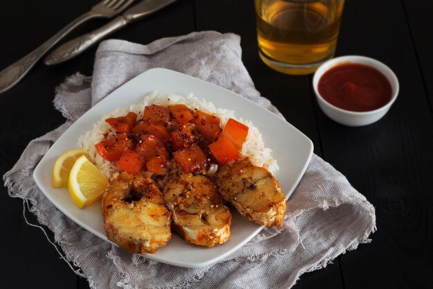 Rebanadas de bacalao frito con arroz, pimienta y ketchup