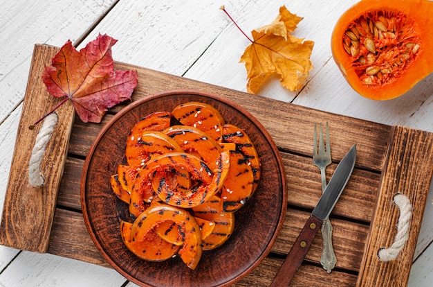 Rebanadas de calabaza a la parrilla en bandeja de madera