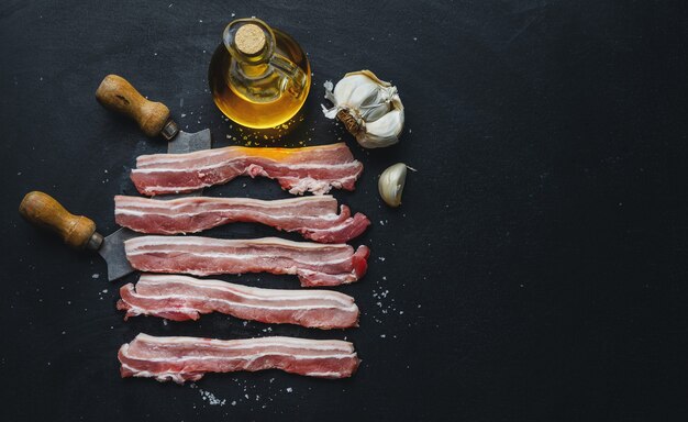 Foto rebanadas de cerdo crudo con especias en la oscuridad. listo para cocinar