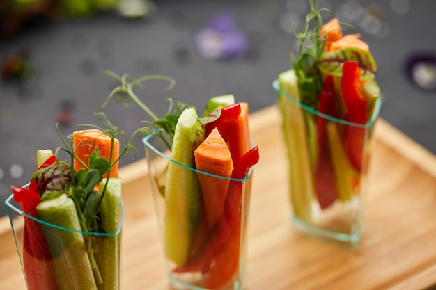 Rebanadas coloridas de vegetales crudos en vasos zanahorias pepino pimiento dulce El concepto de dieta saludable y comida vegetariana