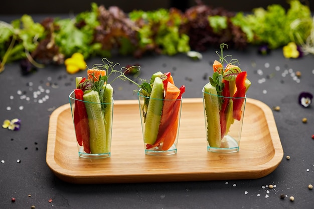 Rebanadas coloridas de vegetales crudos en vasos zanahorias pepino pimiento dulce El concepto de dieta saludable y comida vegetariana