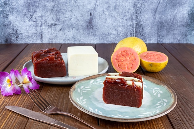 Rebanadas de dulce de guayaba y requesón junto a un tenedor de flores y un cuchillo de cobre