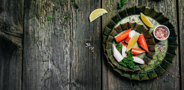 Rebanadas frescas de palitos de cangrejo Surimi en tablero de madera Listo para comer Vista superior de formato de banner largo