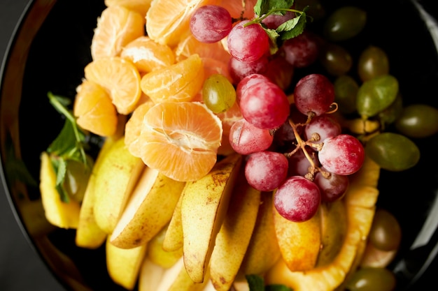 rebanadas de fruta en un primer plano de la placa Las rebanadas de fruta están bellamente dispuestas en el primer plano de la placa