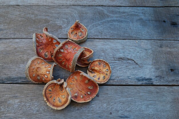 Rebanadas de fruta seca de Bael, en la madera vieja con tono oscuro