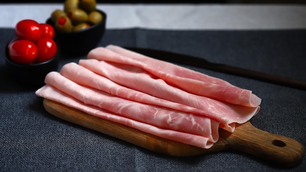 Rebanadas de jamón de cerdo en una tabla de madera