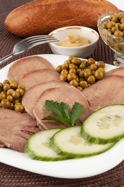 Rebanadas de lengua de ternera hervida con guisantes