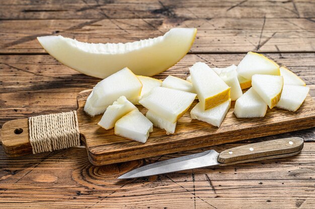 Rebanadas de melón amarillo en la tabla de cortar