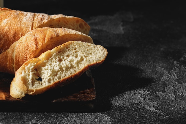 Rebanadas de pan baguette sobre plancha de madera cerrar