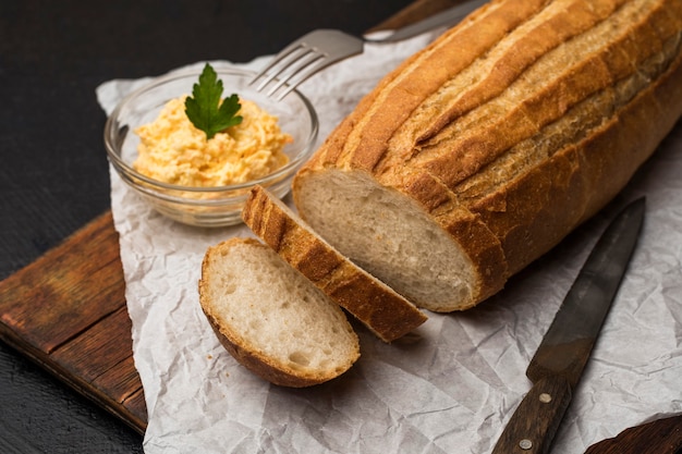 Rebanadas de pan casero sobre una tabla para cortar madera. Hacer sándwiches de queso. De cerca