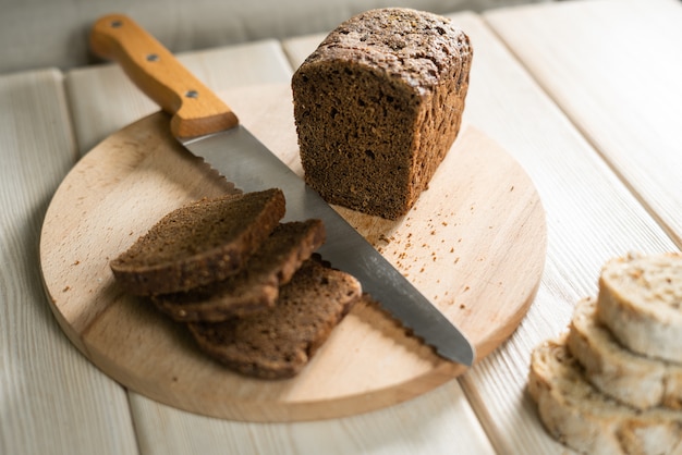 Rebanadas de pan de centeno en la tabla de cortar. Pan integral de centeno con semillas