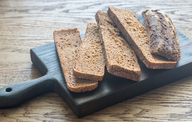 Foto rebanadas de pan de centeno en la tabla de madera