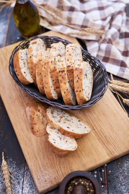 Rebanadas de pan fresco en una tabla de cortar de madera en la mesa de la cocina