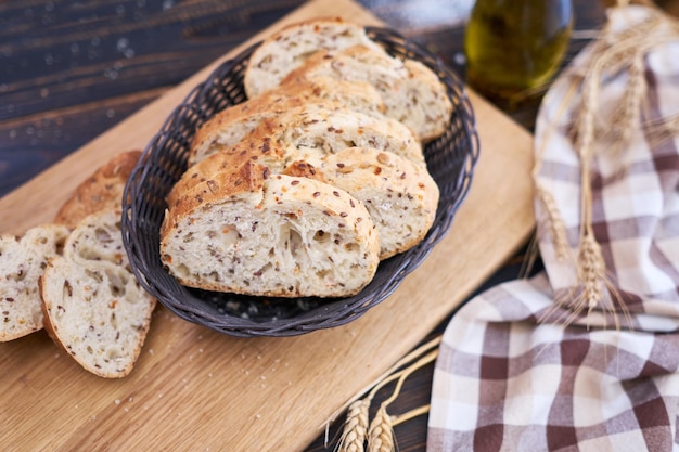 Rebanadas de pan fresco en una tabla de cortar de madera en la mesa de la cocina