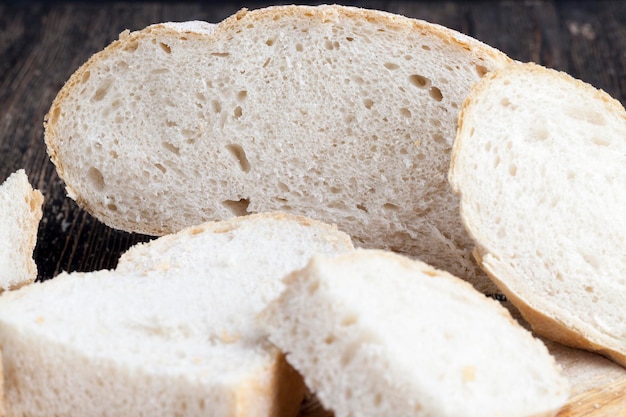 Rebanadas de pan gris de pan de harina de baja calidad de segunda categoría en una tabla para alimentos de harina