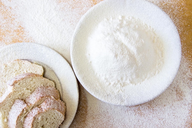 Rebanadas de pan y harina de trigo en un plato blanco sobre la mesa