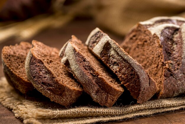 Rebanadas de pan hechas con cacau y chocolate sobre tela rústica sobre mesa rústica de madera con ingredientes.